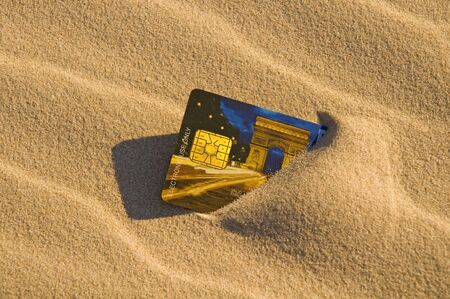 Close up of a credit card left in the sandの写真素材