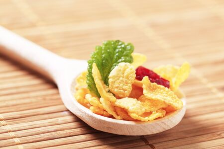 Corn flakes on a wooden spoon の写真素材