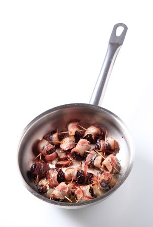 Bacon wrapped prunes in a saucepan の写真素材