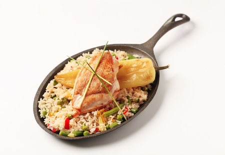 Fried rice and roasted chicken breast on a skilletの写真素材