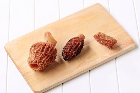 Morel mushrooms on a wooden cutting boardの写真素材