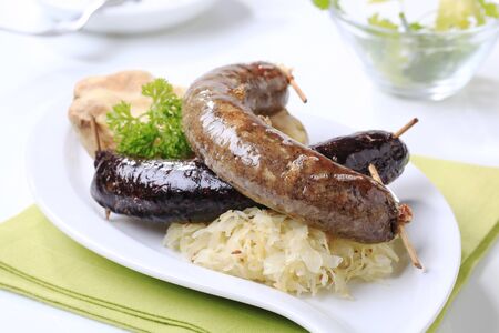 Blood sausage and white pudding with sauerkraut and baked potatoの写真素材