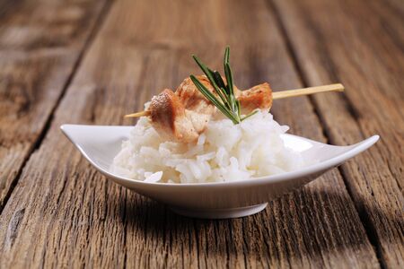 Chicken skewer on bed of white riceの写真素材