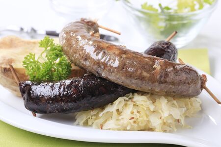Blood sausage and white pudding with sauerkraut and baked potatoの写真素材