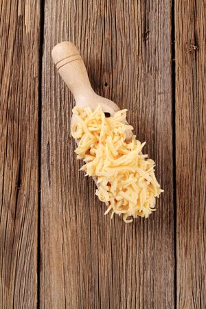 Grated cheese on a wooden scoop - overheadの写真素材