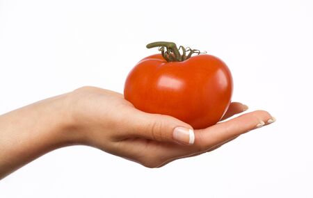Woman's hand holding a red tomatoの写真素材