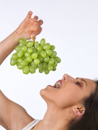 Young woman eating fresh grapesの写真素材