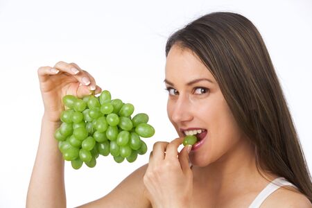 Young woman eating fresh grapesの写真素材