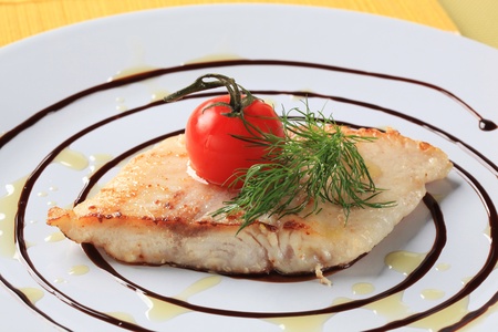 Salmon trout fillet garnished with arugula and balsamic reduction