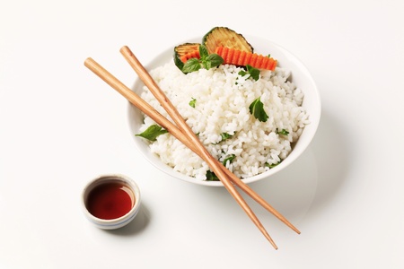 Bowl of cooked white rice with zucchini and soy sauceの写真素材