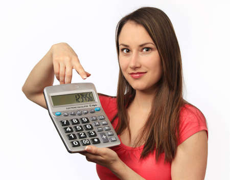 Young woman pointing at numbers on a calculatorの写真素材