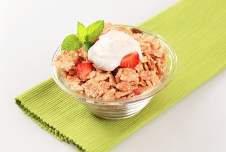 Bowl of breakfast cereal topped with white yogurt 