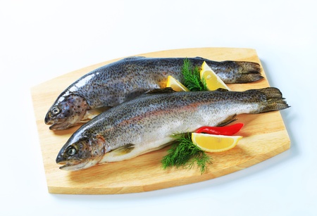 Two fresh trout on a cutting boardの写真素材