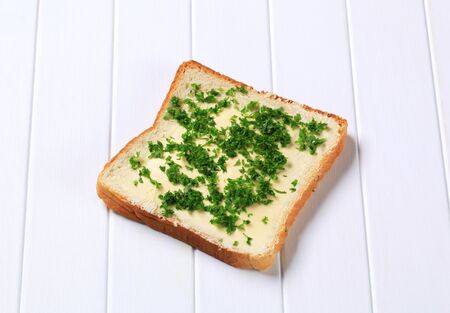 Bread with butter and chopped parsleyの写真素材