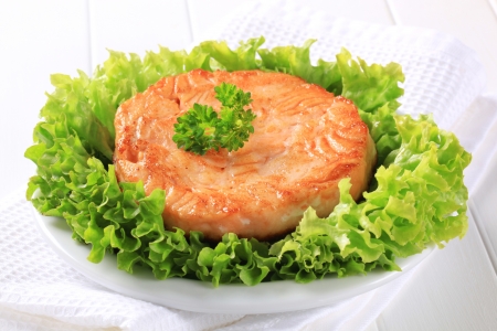 Pan fried salmon patty served on lettuceの写真素材