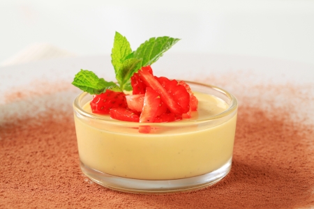 Small dish of custard topped with strawberryの写真素材