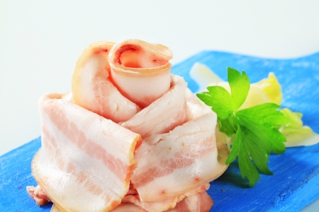 Thin slices of bacon on cutting boardの写真素材