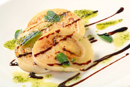 Slices of pan fried aubergine with pesto and balsamic vinegar