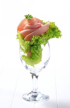 Ham rose and curly lettuce in a glassの写真素材