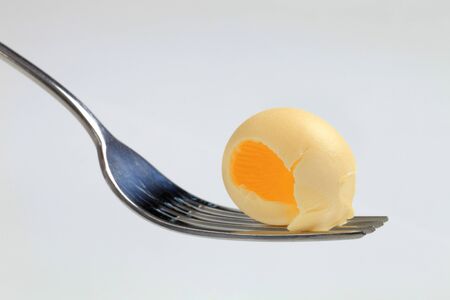 Single butter curl on a metal fork の写真素材