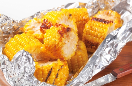 Pieces of grilled sweet corn in tin foilの写真素材