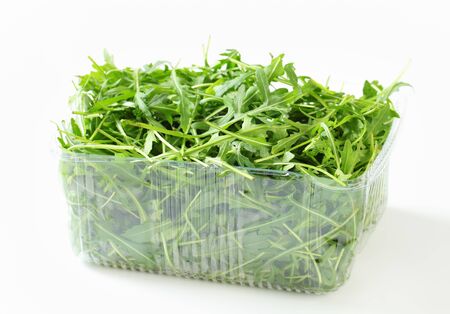 Arugula leaves in plastic containerの写真素材