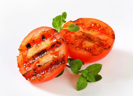 Grilled tomatoes on white cutting boardの写真素材