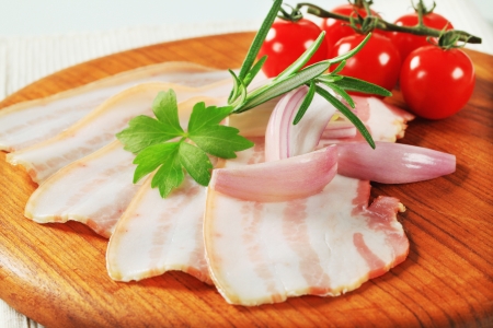 Thin slices of bacon on cutting boardの写真素材