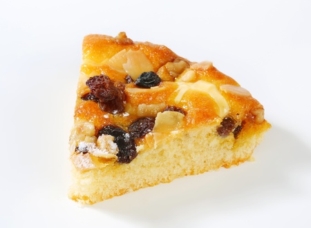 Slice of sponge cake with nuts and raisinsの写真素材