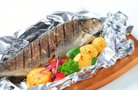 Grilled trout on aluminum foilの写真素材
