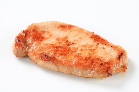 Pan seared pork cutlet isolated on whiteの写真素材