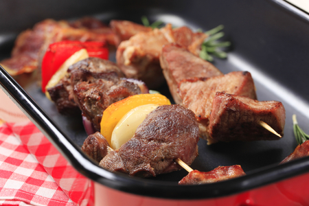 Shish kebabs and rashers of bacon in a roasting panの写真素材