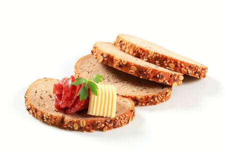 Sliced bread with butter and salamiの写真素材