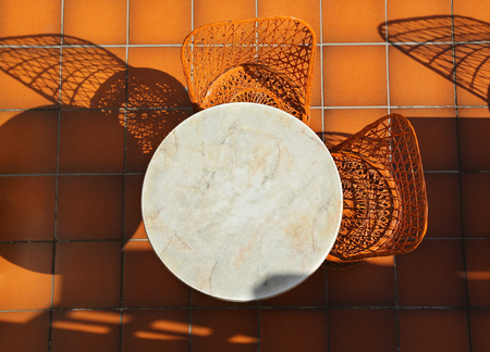 Round table and wicker chairs on tiled terraceの写真素材