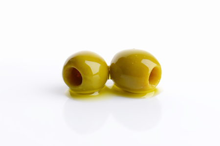 Two pitted green olives on white backgroundの写真素材