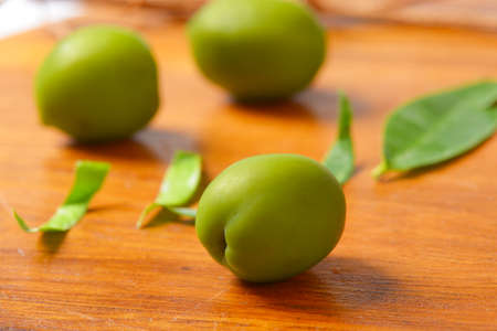 Fresh green olives on wooden backgroundの写真素材