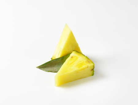Fresh pineapple wedges on white backgroundの写真素材