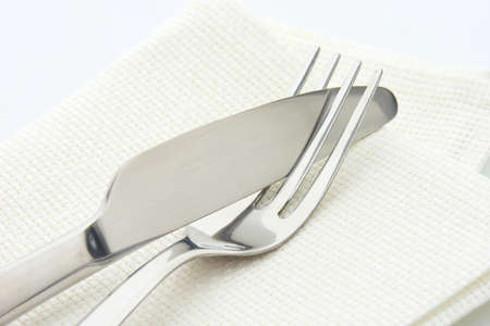 Dinner knife and fork on white napkin