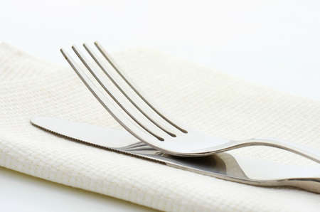 Dinner knife and fork on white napkin