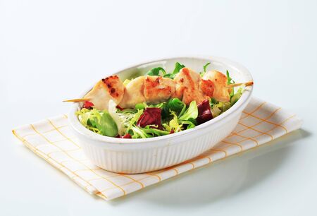Chicken skewer and mixed salad greensの写真素材