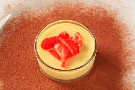 Small dish of custard topped with strawberryの写真素材