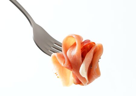 Thin slices of Prosciutto on a forkの写真素材