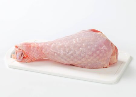 Raw turkey leg on cutting boardの写真素材