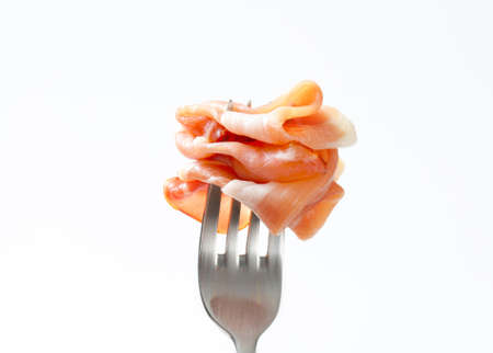 Thin slices of Prosciutto on a forkの写真素材
