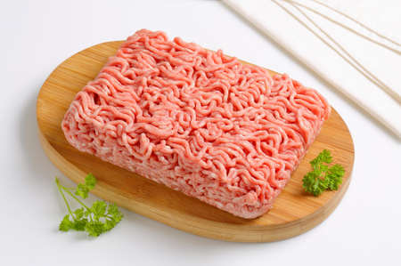 Raw ground pork on cutting boardの写真素材