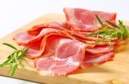 Slices of smoked pork neck on cutting boardの写真素材