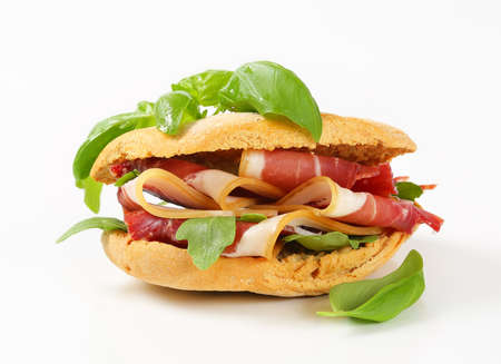 Sliced prosciutto crudo between slices of crispy breadの写真素材