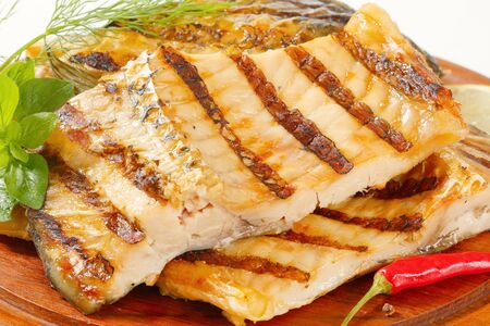 Grilled carp fillets on cutting board