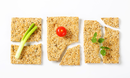 Whole wheat crackers with sesame seeds and chopped herbsの写真素材