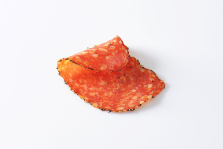 Thin slice of black pepper-coated salami speckled with pieces of Comte cheeseの写真素材